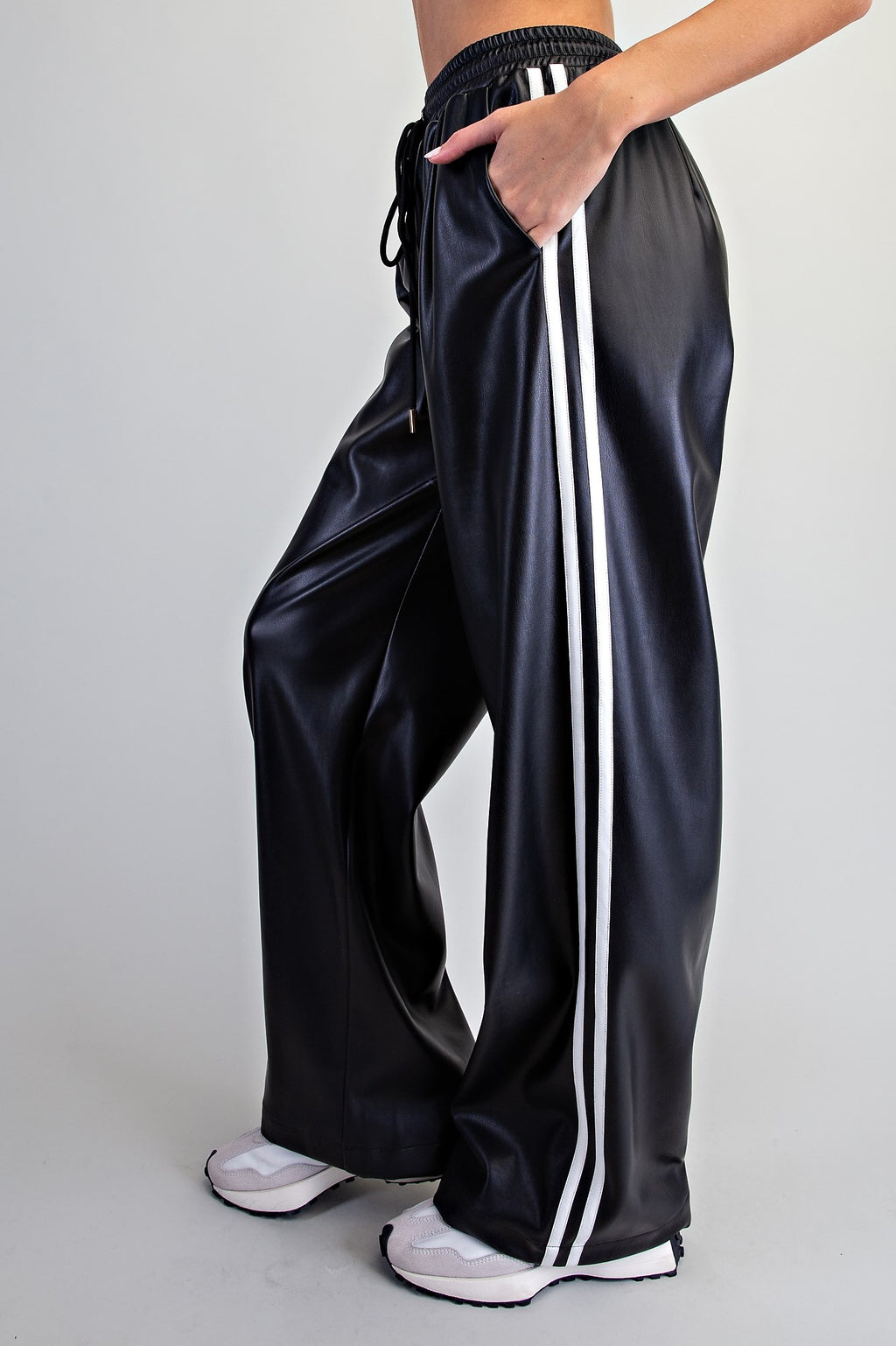 Side view of black faux leather wide-leg pants with white double stripes and a side pocket.