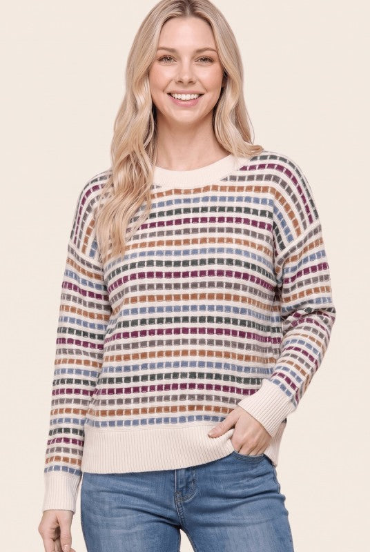 Front view of a model wearing a Staccato cream textured sweater with magenta, camel, and blue-gray stripes.